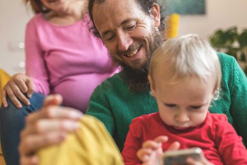 Man sitting with a young child on a phone