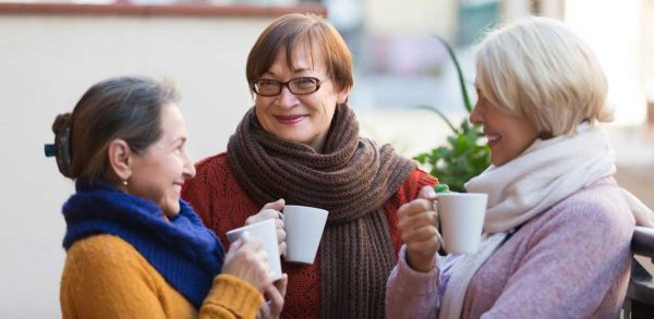 Three women drinking coffee and talking together