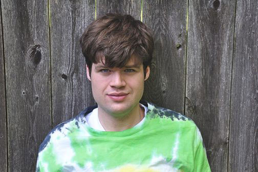 Young man standing in front of a fence