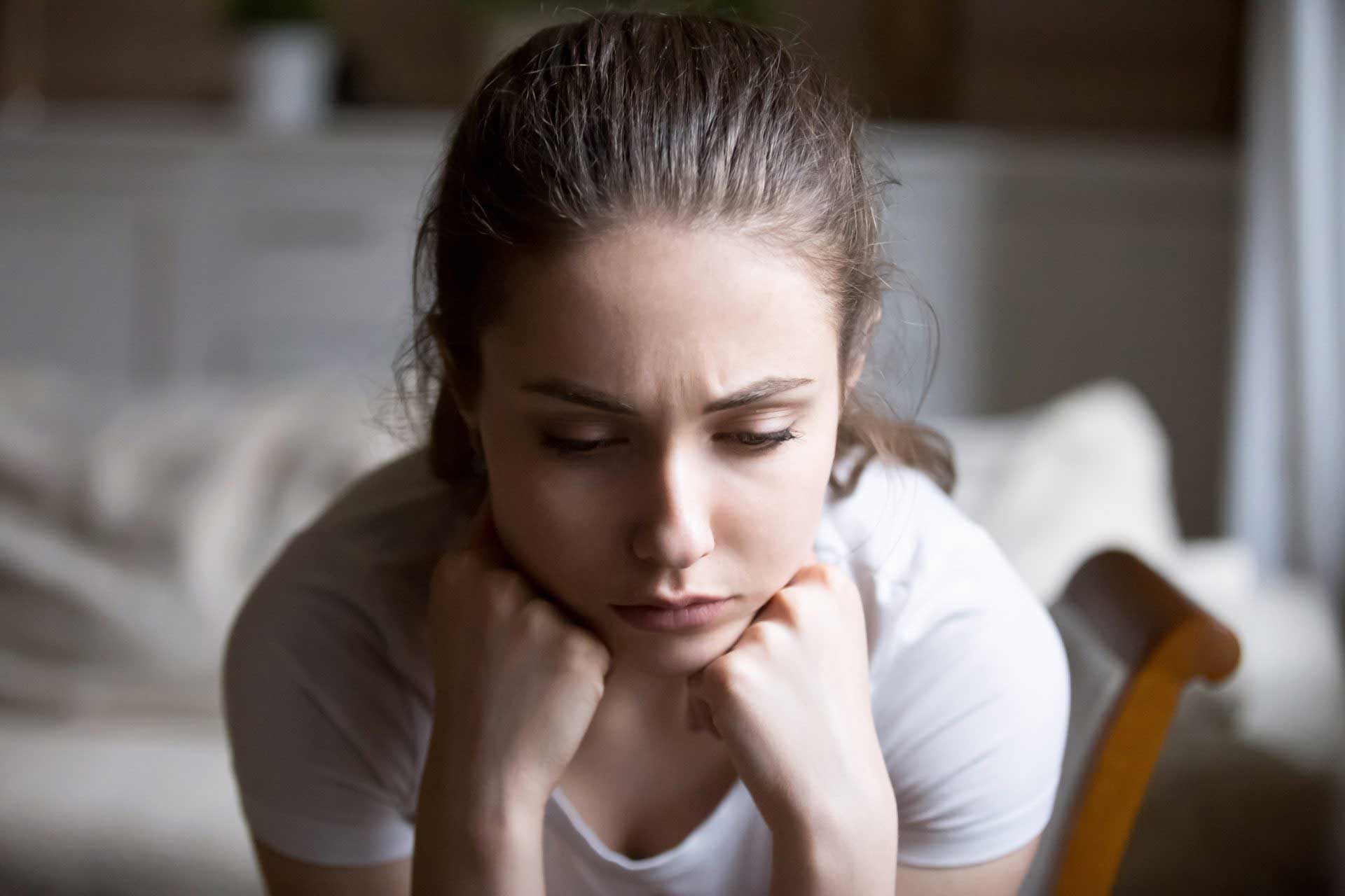 Sad young woman resting her head on her hands